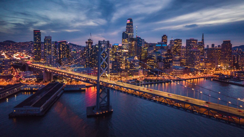 a view of san francisco bridge and its skyline with buildings in the background