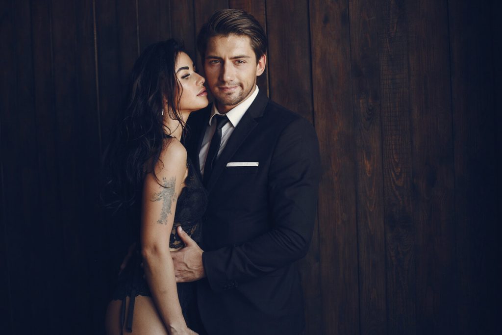 a sexy woman from los angeles who is an escort is beside a man in formal black suit