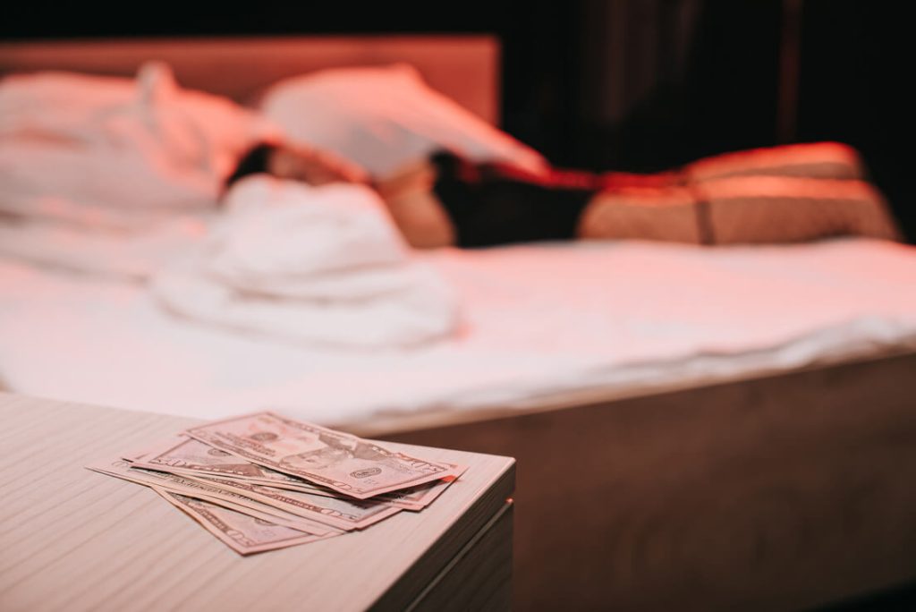 an escort from nashville laying on the bed with a money on the table