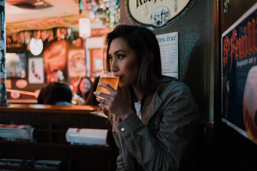 a woman from indianapolis sipping her cocktail drink in a  night bar