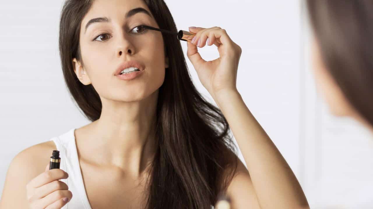 a beautiful woman putting on her makeup as she is about to personally meet her date